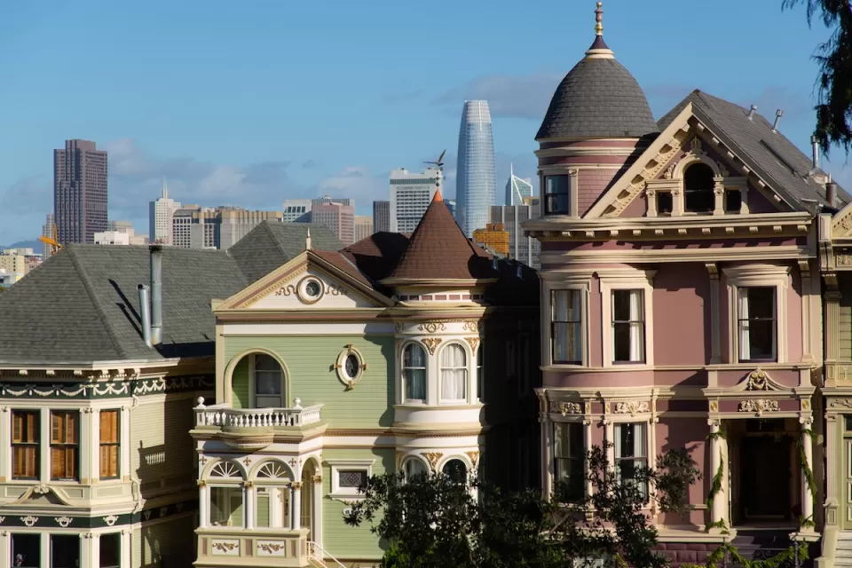 Ornate Victorian San Francisco houses with modern high-rises in background.